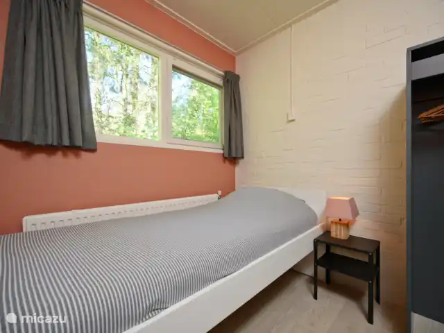 Slaapkamer met 1-persoonsbed en kledingkast